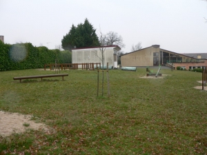 Derri&egrave;re le pr&eacute;fabriqu&eacute; (qui n'y &eacute;tait pas &agrave; l'&eacute;poque) on aper&ccedil;oit la 1&egrave;re &eacute;cole maternelle (Ph. G. BRANCHUT 2006)